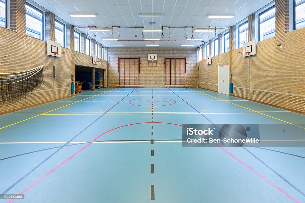 Interior dutch gymnasium for school sports Empty european gym class for school sports no people. In the netherlands the teenagers learn several different sports on high school. I took this photo of a gym or gymnasium on the secondary school in enschede where I work. I like the bent or curved lines on the floor with no people in the image. School Gymnasium Stock Photo