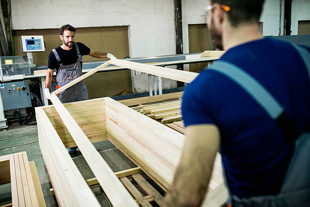 Carpenters carrying wood plank
