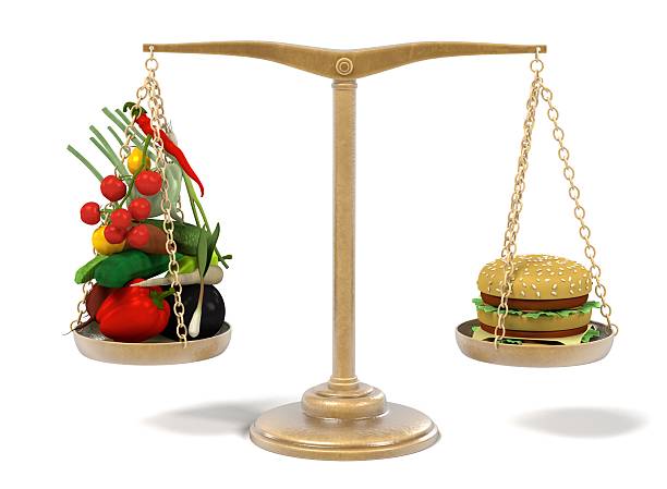 istock hamburger and vegetable on scales 629387530