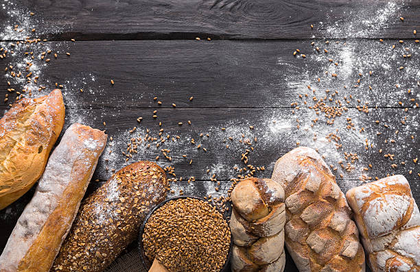 istock Bread bakery background. Brown and white wheat grain loaves composition 629388752