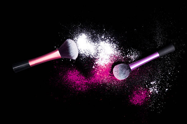 istock Make-up brushes with colorful powder spilled glitter dust on black. 629391366