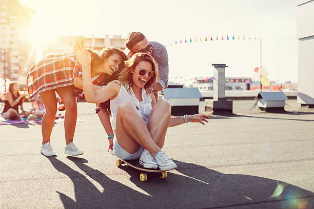 Teenagers skateboarding on rooftop terrace Girls having fun on a skateboard balcony photos stock pictures, royalty-free photos & images