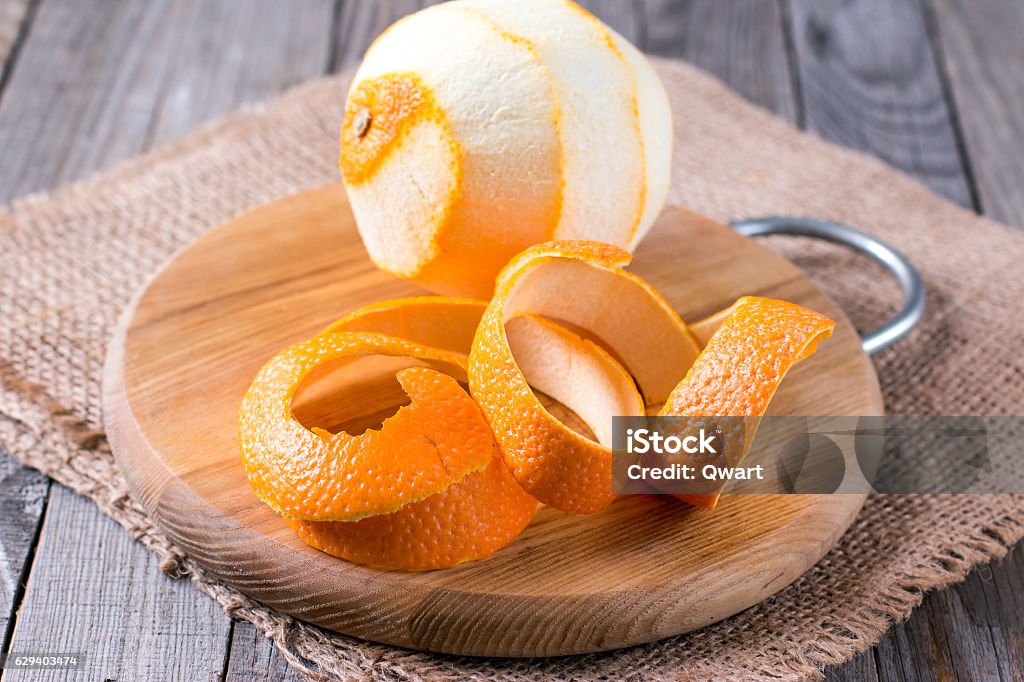 peeled orange on the wooden background A peeled orange on the wooden background Peel - Plant Part Stock Photo