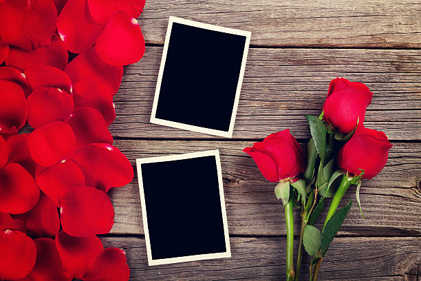 istock Red roses, photo frames and petals 629404118