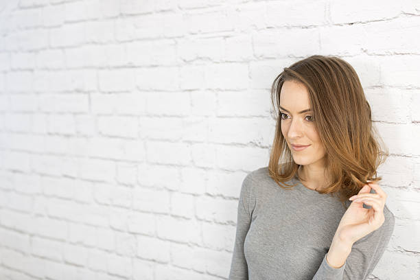 istock Woman standing next to a white wall 629406176
