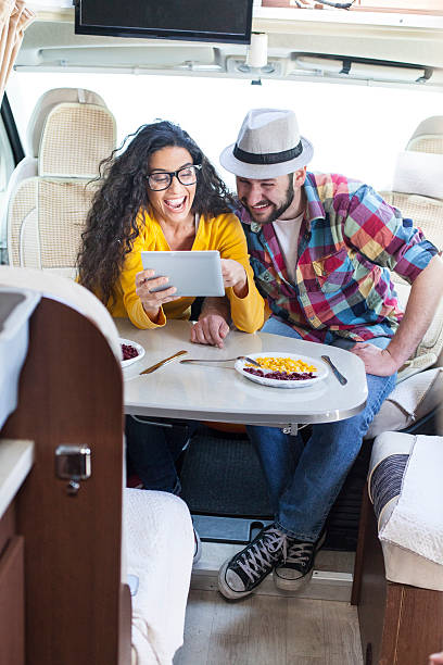 istock Couple having fun and using digital tablet inside of caravan 629406838