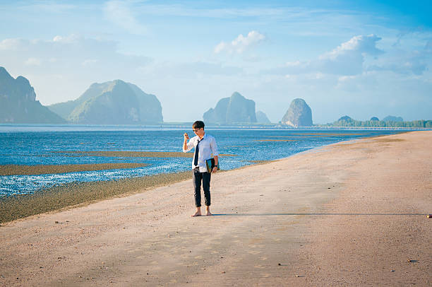 istock Asian Business man relaxing on beach using laptop and smartphone 629407994