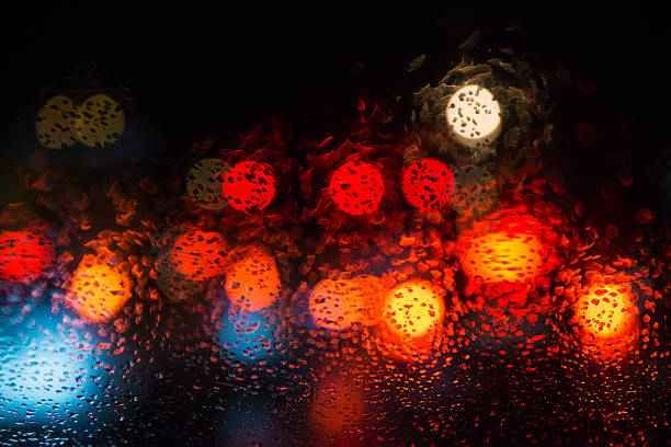 Rain drops on window with street bokeh lights. stock photo