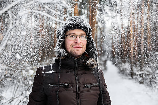 istock Man in fur winter hat with ear flaps smiling portrait 629412202