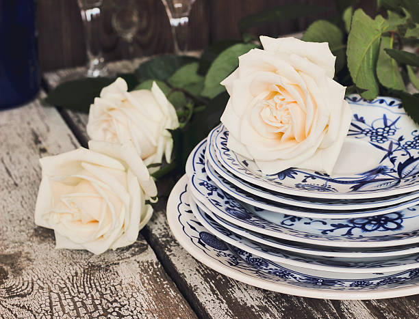 istock Clean plates with white roses on a wooden table 629412950
