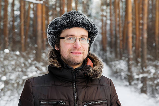 istock Man in fur winter hat with ear flaps smiling portrait 629413144