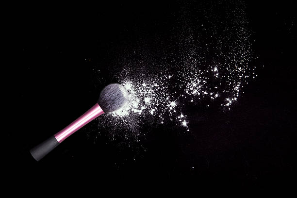 istock Make-up brushes with colorful powder spilled glitter dust on black. 629413256
