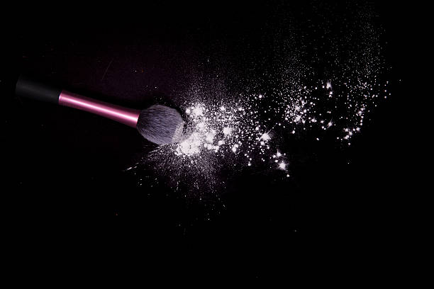 istock Make-up brushes with colorful powder spilled glitter dust on black. 629413360