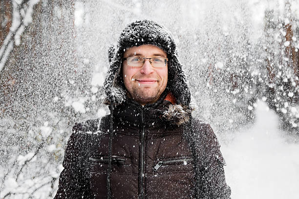 istock Man in fur winter hat with ear flaps smiling portrait 629413400