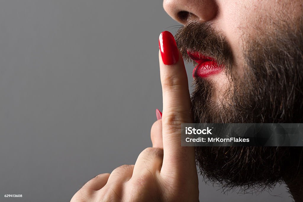 Transgender Making Silence Gesture Bearded Man with Red Lipstick on His Lips and Nail Polish Making Silence Gesture Men Stock Photo