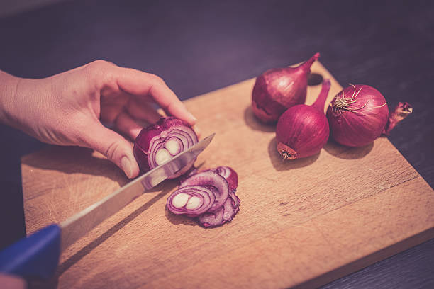 istock Cutting onions with knife on cutting board 629419214