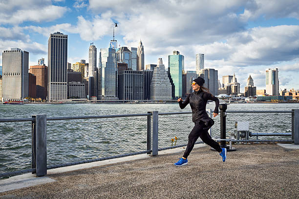 спортсменка бег трусцой на пирсе - footpath lower manhattan horizontal new york city стоковые фото и изображения