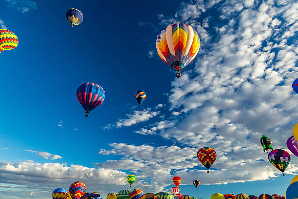 Albuquerque Hot Air Balloon Fiesta 2016 Hot Air Balloons fly over the city of Albuquerque, New Mexico during the mass ascension at the annual International Hot Air Balloon Fiesta in October, 2016 ballooning festival stock pictures, royalty-free photos & images