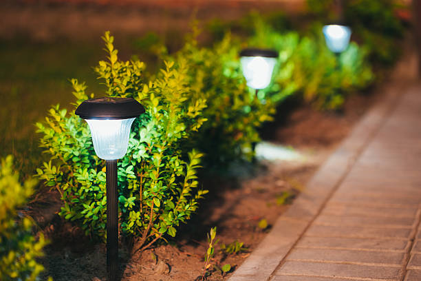 pequeña linterna, luz solar jardín, en flor. diseño del jardín. - artificial lighting fotografías e imágenes de stock