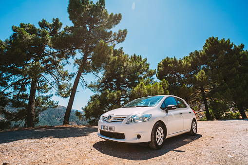 Mijas, Spain - June 19, 2015: White color Toyota Auris car on Spain nature landscape. The Toyota Auris is a compact hatchback derived from the Toyota Corolla