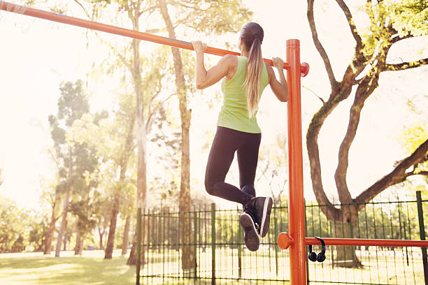 Fit woman exercising outdoors Fit woman exercising outdoors, healthy lifestyle and exercise concept chin ups photos stock pictures, royalty-free photos & images