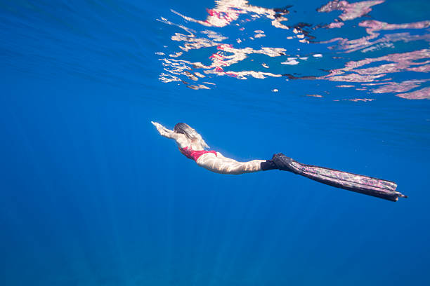 istock Young woman diving into blue 629444008