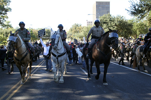 Austin, Texas, USA - November 19, 2016: Mounted Texas Department of Public Safety troopers protect a 'White Lives Matter' march from counter-demonstrators near the Capitol. The 'White Lives Matter' demonstrators, numbering about 20 people at the most, came from Houston with the message that the federal hate crime law is unfair to white people.
