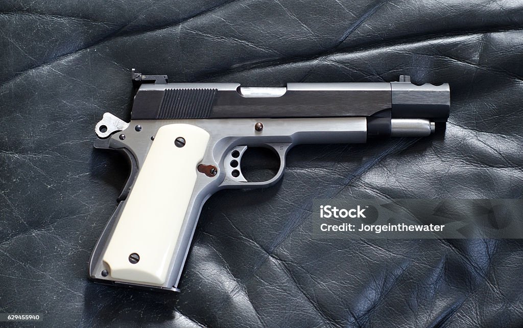 Antique 45 caliber 1911 pistol A 45 caliber1911 pistol with hammer cocked, and built in compensator Foal - Young Animal Stock Photo