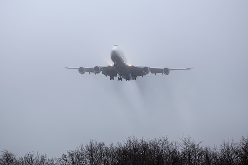 Frankfurt, Germany - December 13, 2016: Landing approach of Boeing 747 of German airline Lufthansa at Frankfurt International Airport in dense fog. Boeing 747 (also known by it's nickname Jumbo-Jet) is a four-engine, wide body commercial airliner. The german airline Lufthansa is the largest airline in Europe and the world's fifth-largest airline and part of the intercontinental airline network Star Alliance.