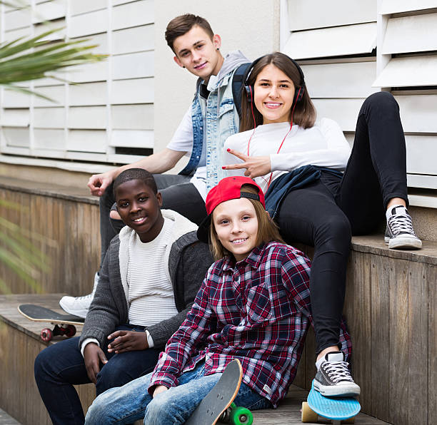 istock girl and three boys hanging out outdoors and discussing somethin 629458478