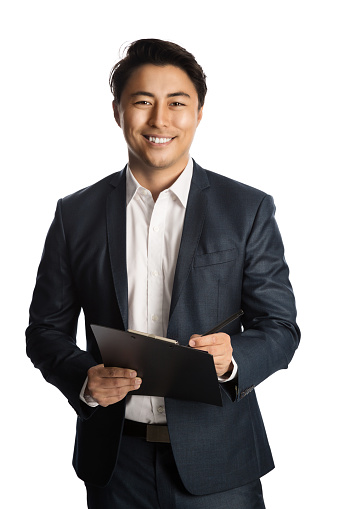 Attractive businessman in a blue suit and white shirt, holding a clipboard and a pen. Standing against a white background with a big toothy smile.