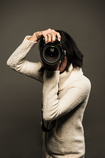 Professional female photographer is holding a camera