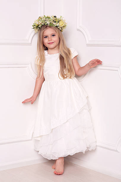 bambino in abito con corona floreale. sfondo bianco - judy garland foto e immagini stock