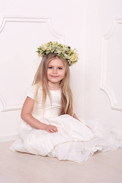 bambino in abito con corona di fiori. sfondo bianco - judy garland foto e immagini stock