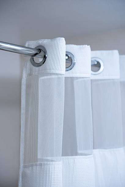 Shower curtain on shower curtain rod Shower curtain hanging from a chrome shower curtain rod clothes hanger rod stock pictures, royalty-free photos & images