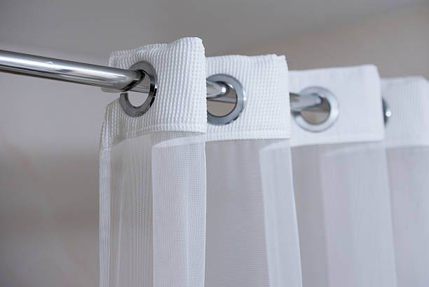 Shower curtain on shower curtain rod Shower curtain hanging from a chrome shower curtain rod clothes hanger rod stock pictures, royalty-free photos & images