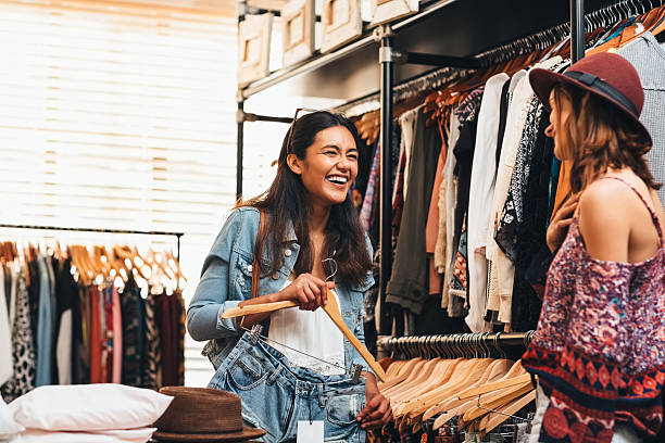Best friends make the best shopping mates Shot of two friends shopping in a clothing boutique clothing store stock pictures, royalty-free photos & images