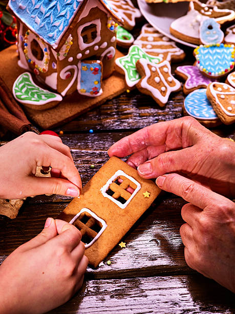 la abuela y la nieta juntas hacen una casa de pan de jengibre para navidad. - cake old fashioned gift women fotografías e imágenes de stock