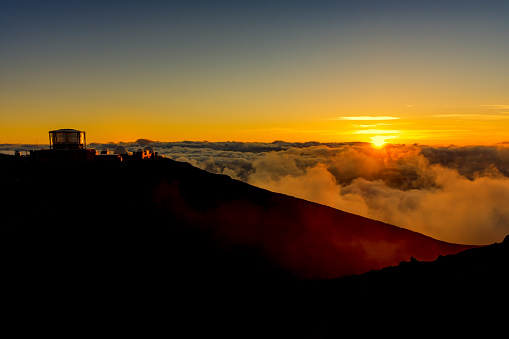 Sunset at the summit of Haleakala National Park with the observatory in the background Maui Hawaii USA