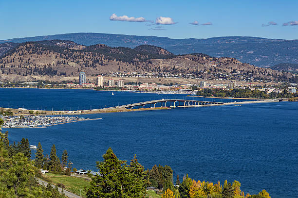 Okanagan Lake Bridge Kelowna BC Canada A view of the bridge over Okanagan Lake between West Kelowna and Kelowna Brititsh Columbia Canada with a view of the Kelowna skyline and a marina in the foreground kelowna-autumn stock pictures, royalty-free photos & images