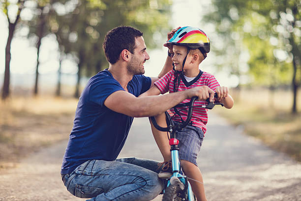 istock Small boy on bicycle talking to his father in nature. 629527240