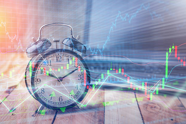 istock Clock alarm with stock graph chart in laptop screen background.T 629527604