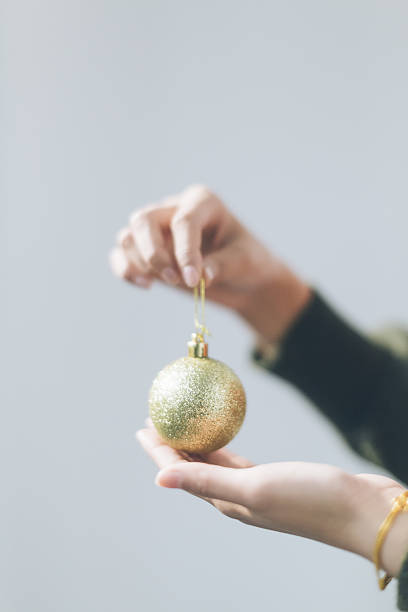 istock hand holding christmas bauble on a light background 629529054