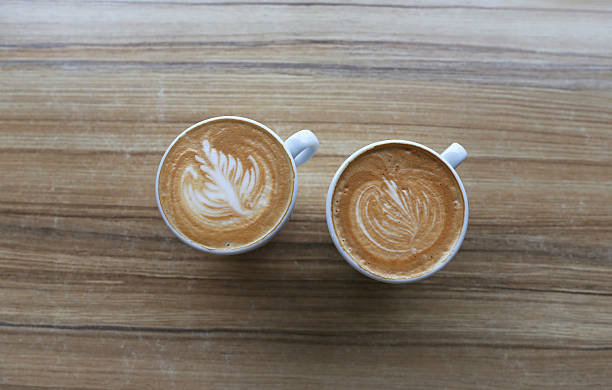 istock Two cups of cappuccino isolated stand on the table 629532066