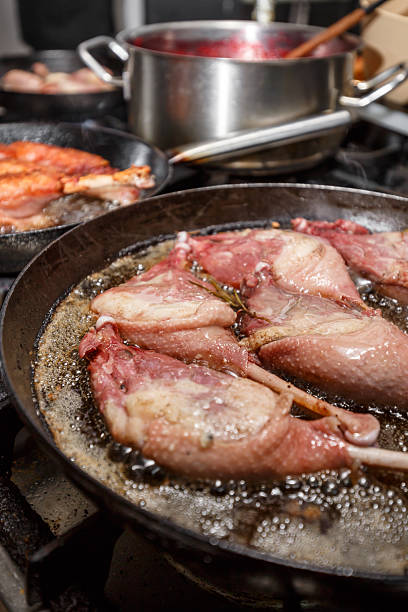 Goose drumstick frying in a pan