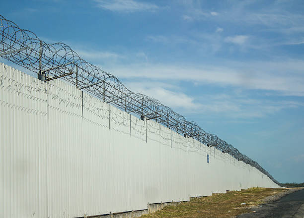 istock Barbed wire fence on blue sky 629532420