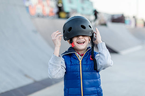 istock Smiling boy putting safety helmet 629534400