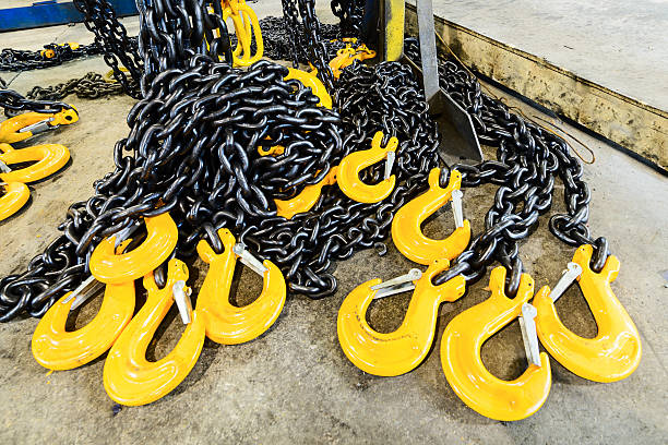 istock Black steel chain and yellow cargo hooks. 629553098
