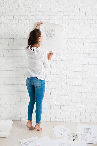 Female artist looking at her work in workshop