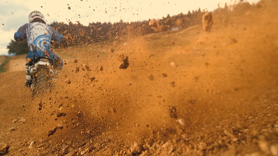 Motocross rider riding on dirt track.